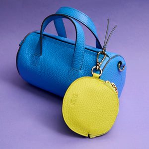 Blue sai italian leather handbag with a yellow round pouch on a purple background - AZURE