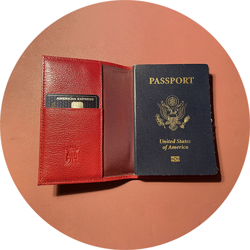 US passport and credit card in an open red leather wallet.