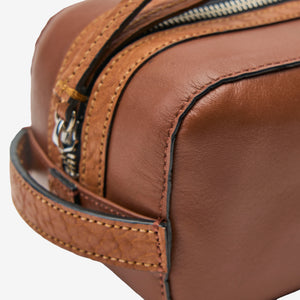 Tusk 770 Italian leather toiletry bag in Wood, close-up detail — embossed logo and fine stitching highlight the expert craftsmanship - WOOD