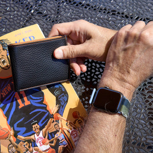 Man holding black pebble grain billfold - BLACK