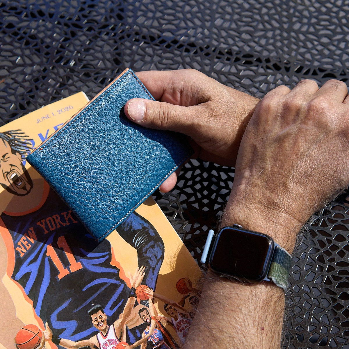 Man holding blue pebble grain leather billfold - DENIM