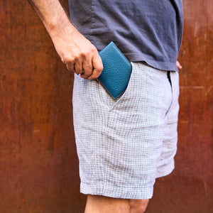 Man inserfting blue pebble grain lather billfold in pant pocket - DENIM 