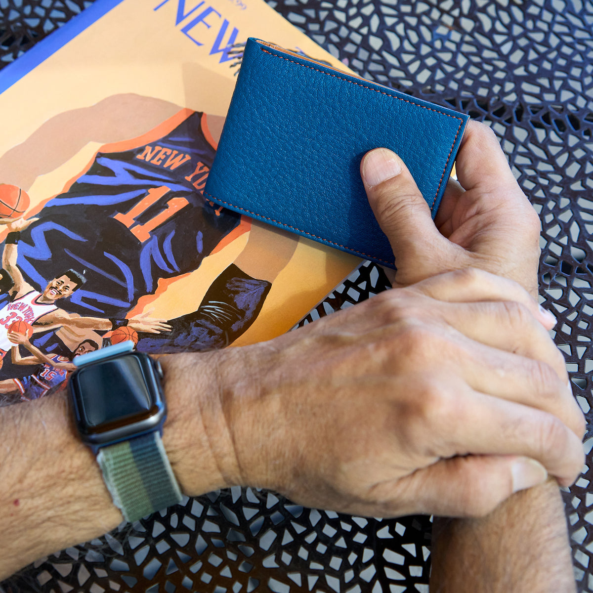 Man holding blue pebble grain leather billfold - DENIM