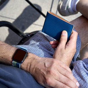 Man holding blue pebble grain leather billfold - DENIM