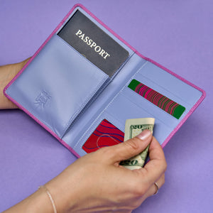 Magenta passport holder with pink trim on a purple background - MAGENTA