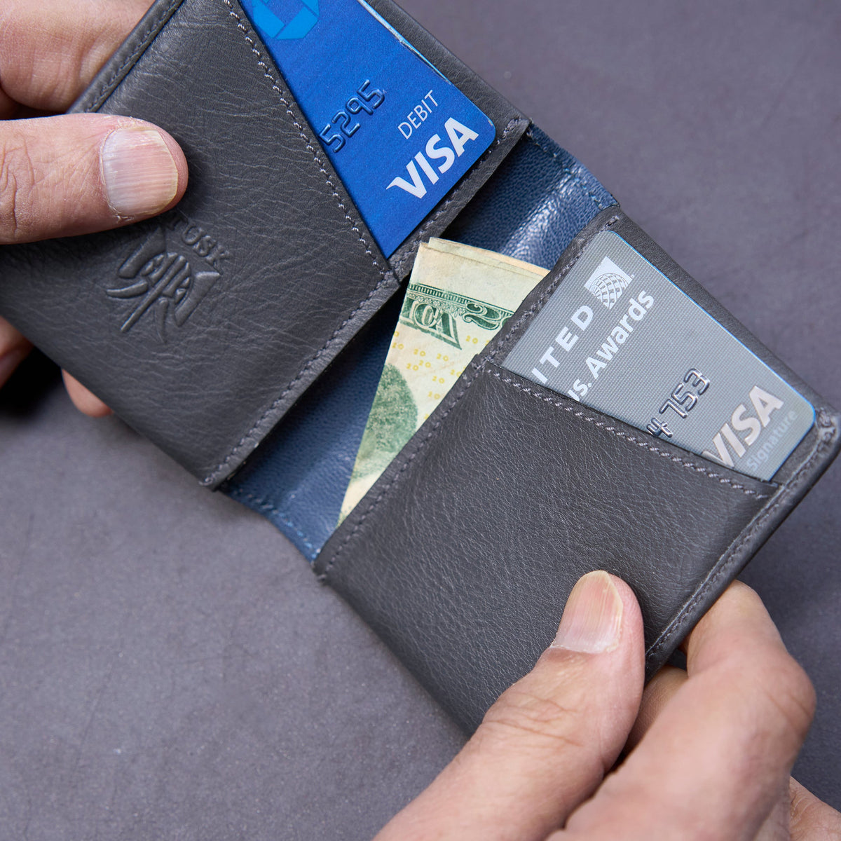 Black leather wallet with cards and money on a gray background - GREY