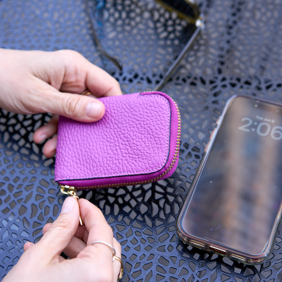 Tusk 194 Ascot small zip card wallet, close-up of the textured leather exterior held in hand - MAGENTA