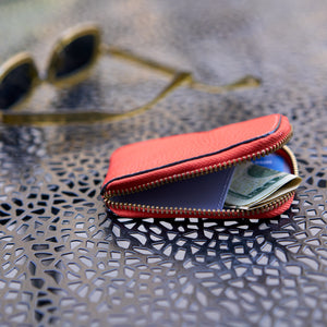 Tusk 194 Ascot small zip card wallet, partly open with folded cash beside sunglasses - ORANGE