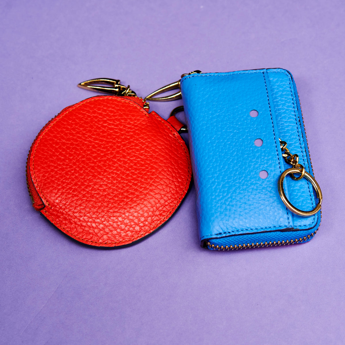 Blue leather wallet on a purple background with orange round coin purse - AZURE