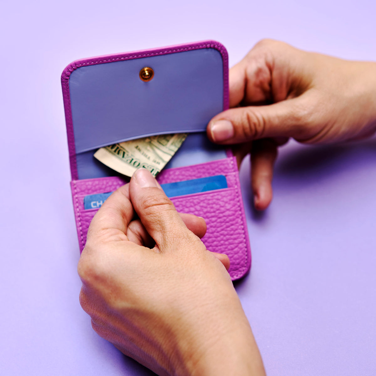 Purple leather wallet with money and cards on a purple background - MAGENTA