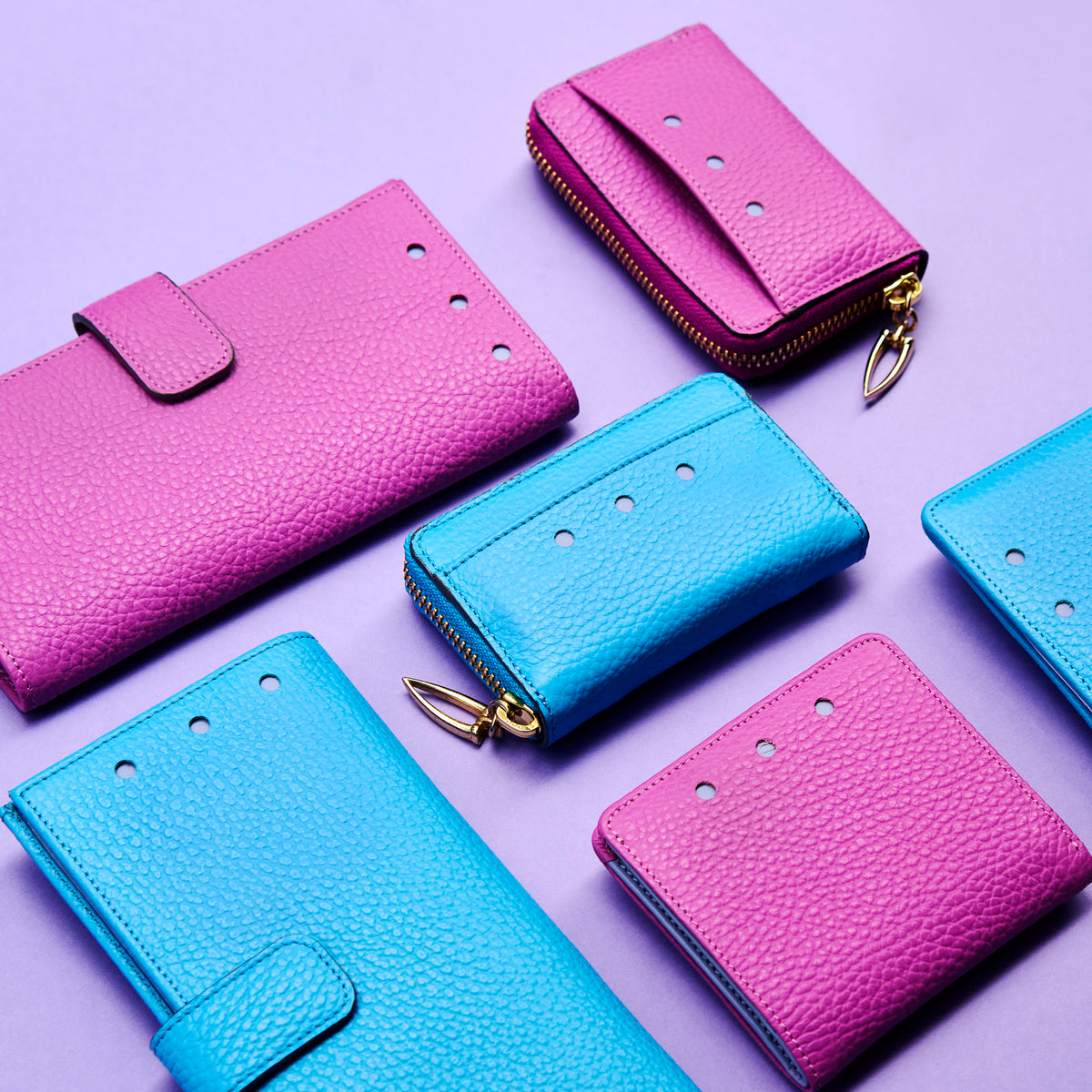Magenta and blue leather wallets on a purple background - MAGENTA