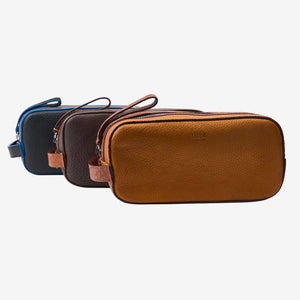 Three leather toiletry bags in brown, black, and tan on a white background - CHOCOLATE