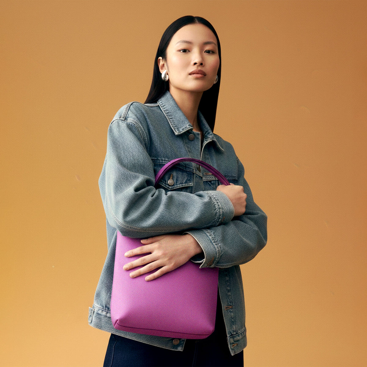 Woman holding a pink tote bag against an orange background - MAGENTA