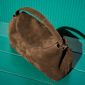 Brown suede handbag on a green surface - BROWN
