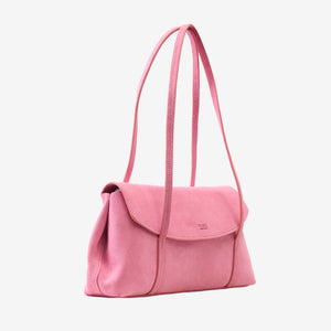 Side view of the blush pink Italian suede Vienatta | Jyoti shoulder bag, displaying its angled profile, structured base, envelope flap closure with stamped Tusk logo, and thin double shoulder straps, set against a plain light gray background - BLUSH