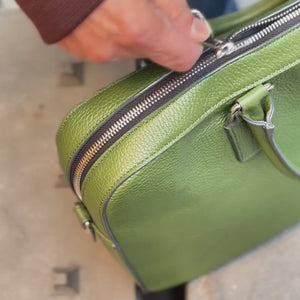 Man placing a laptop and iPad into a green leather briefcase (video) - FOREST