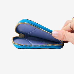 Tusk 194 Ascot small zip card wallet, open and held in hand - AZURE