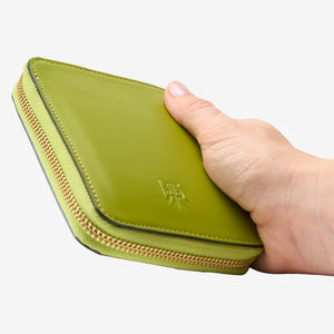 Tusk Lille medium leather zip-around wallet, shown in hand - AVOCADO