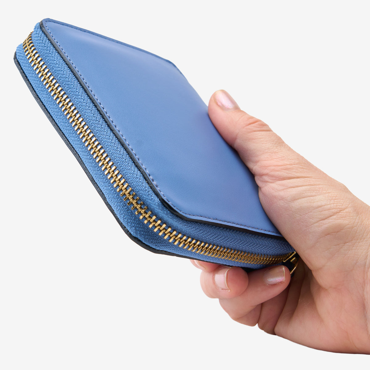 Tusk Lille medium leather zip-around wallet, shown in hand - FRENCH BLUE