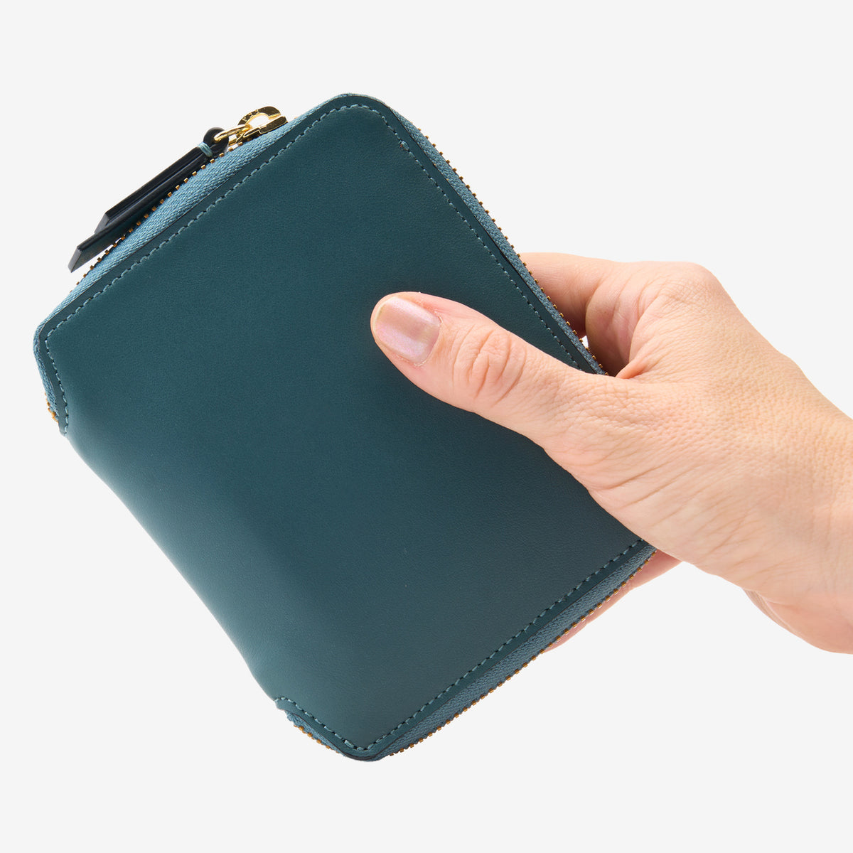 Tusk Lille medium leather zip-around wallet, shown in hand - HUNTER