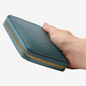 Tusk Lille medium leather zip-around wallet, shown in hand - HUNTER