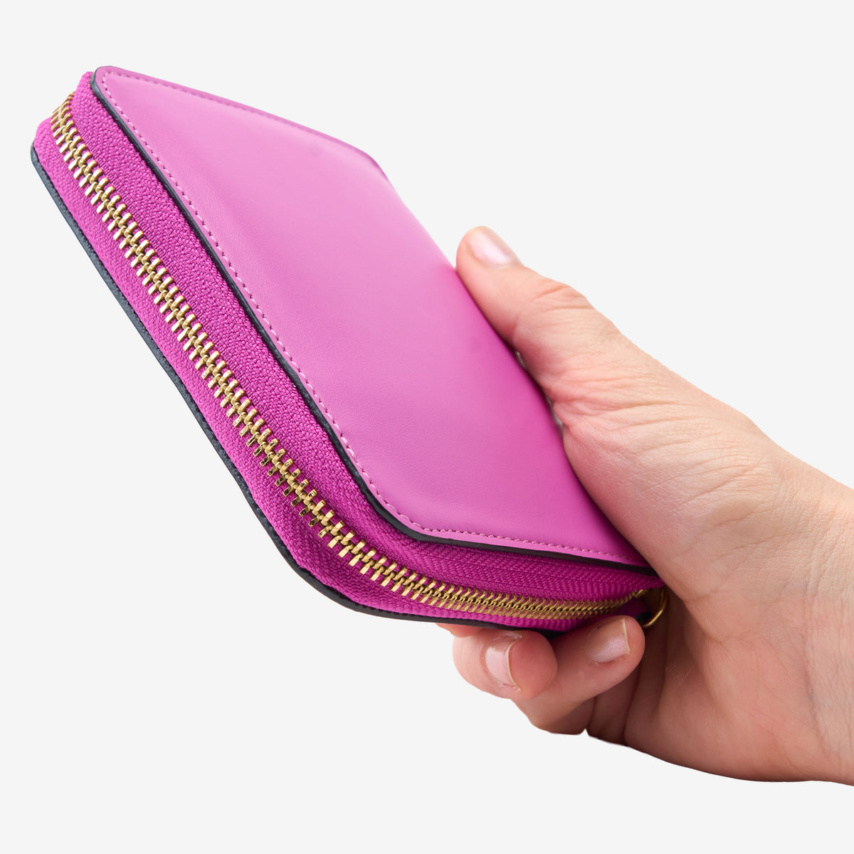 Tusk Lille medium leather zip-around wallet, shown in hand - MAGENTA