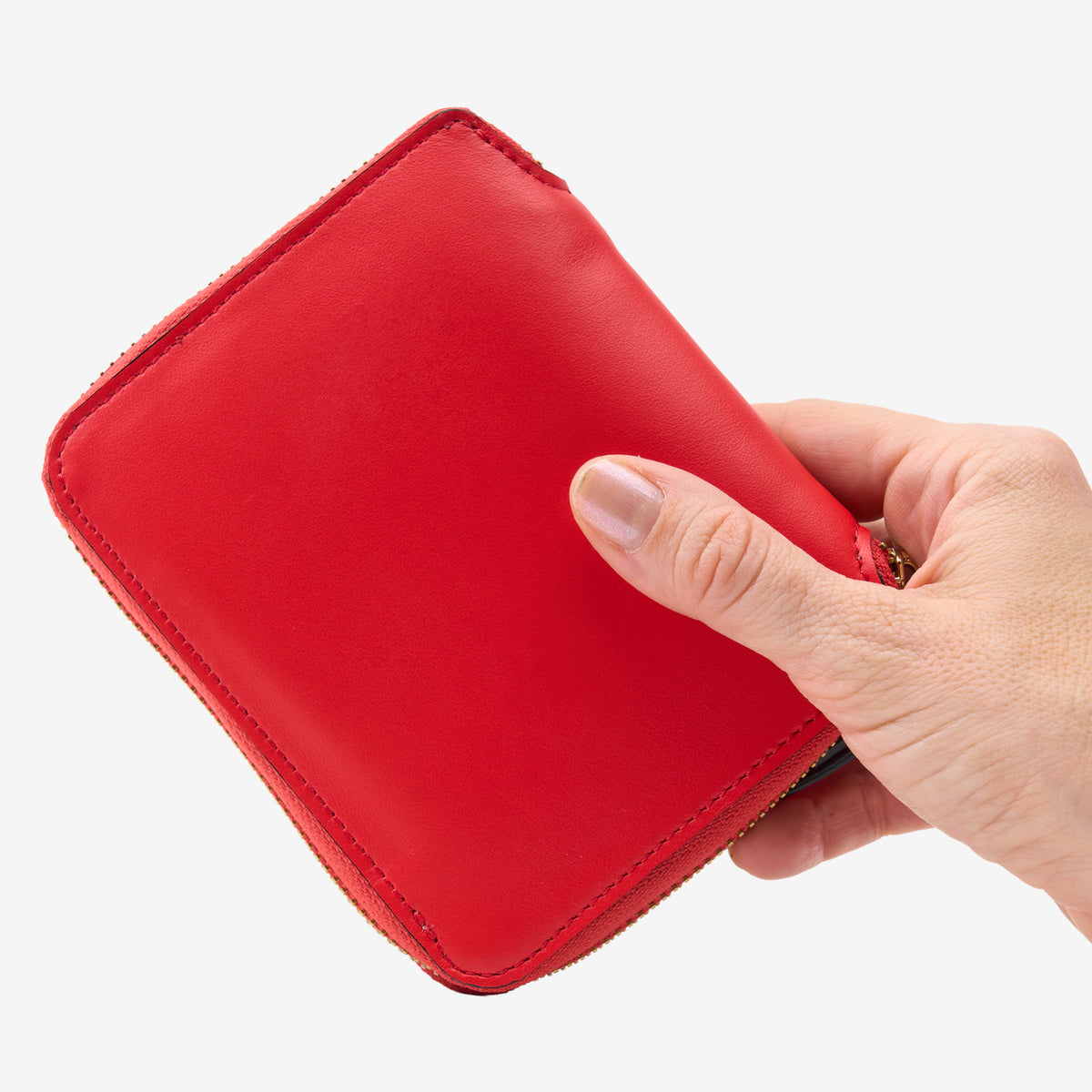 Tusk Lille medium leather zip-around wallet, shown in hand - RED