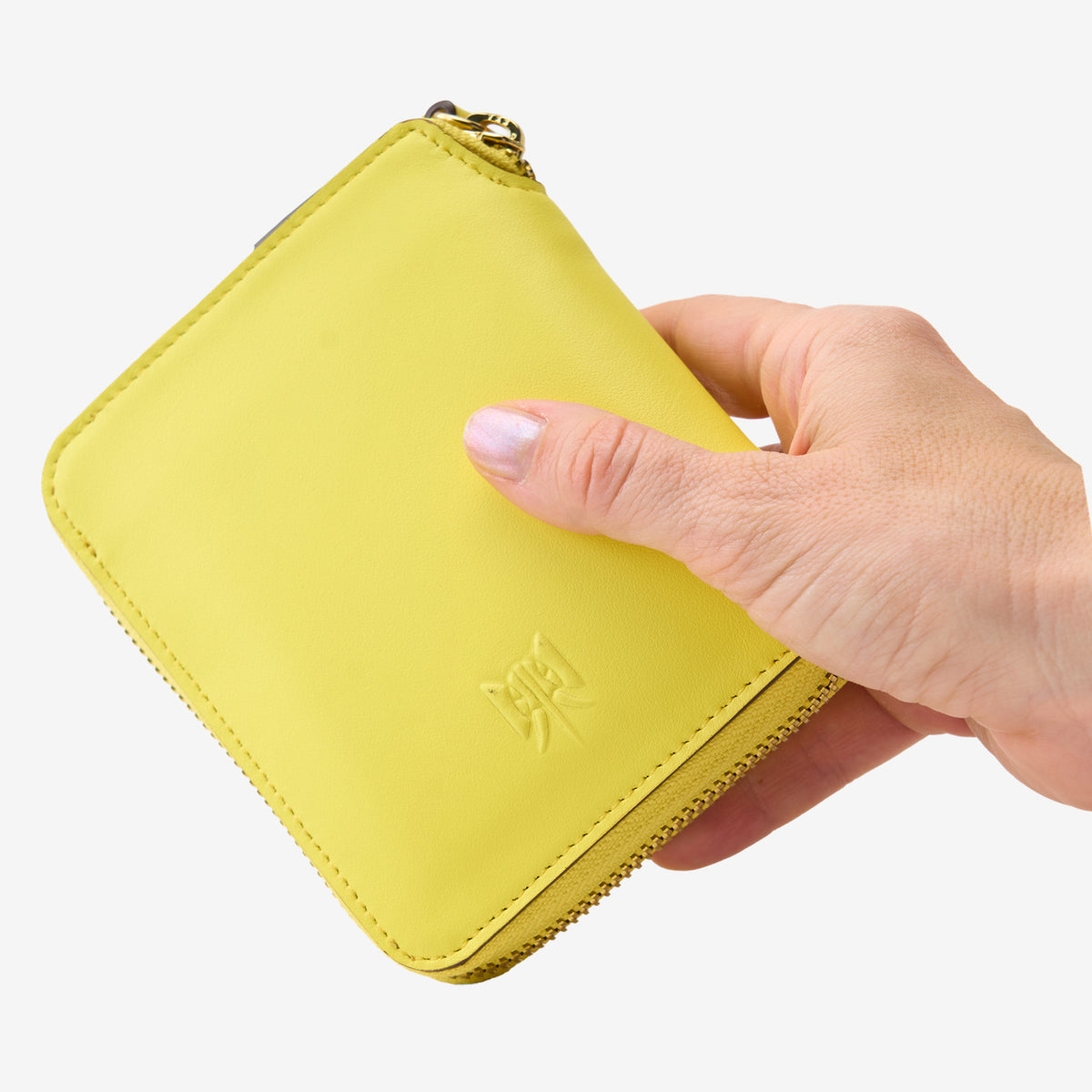 Tusk Lille medium leather zip-around wallet, shown in hand - SUN