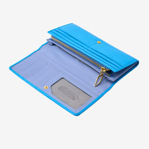 Interior view of the open Ascot flap-over wallet in azure blue pebbled leather, displaying its soft lavender leather lining, multiple card slots, a clear ID window, and a gold-tone zipper compartment with a tusk shaped pull tab - AZURE