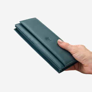 Tusk Lille leather clutch wallet, held in hand – HUNTER GREEN