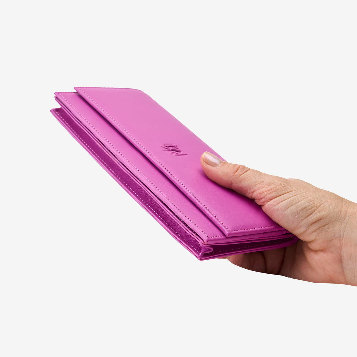 Tusk Lille leather clutch wallet, held in hand – MAGENTA