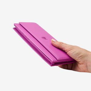 Tusk Lille leather clutch wallet, held in hand – MAGENTA
