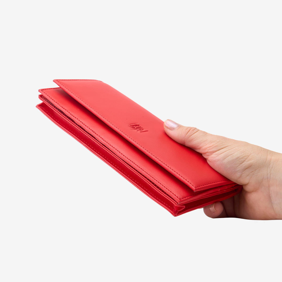 Tusk Lille leather clutch wallet, held in hand – RED