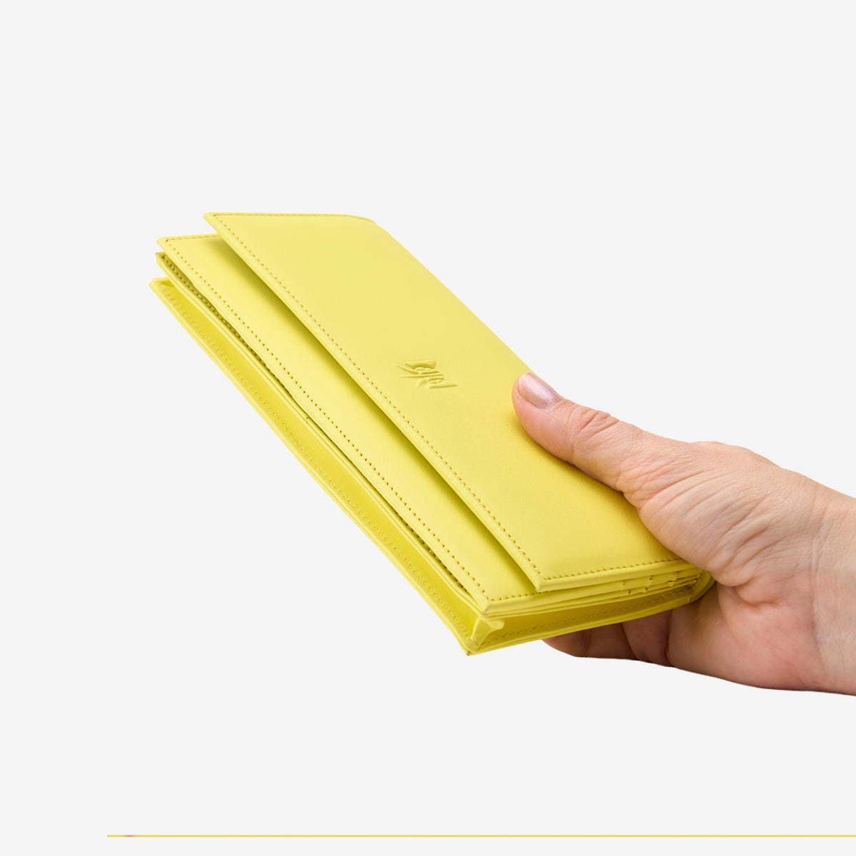Tusk Lille leather clutch wallet, held in hand – SUN