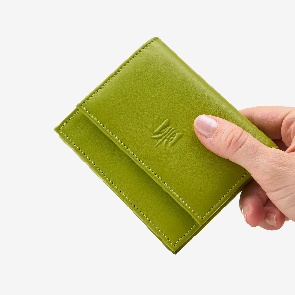 Tusk Lille gusseted French leather wallet in avocado green, held in hand to show its compact size, view one - AVOCADO