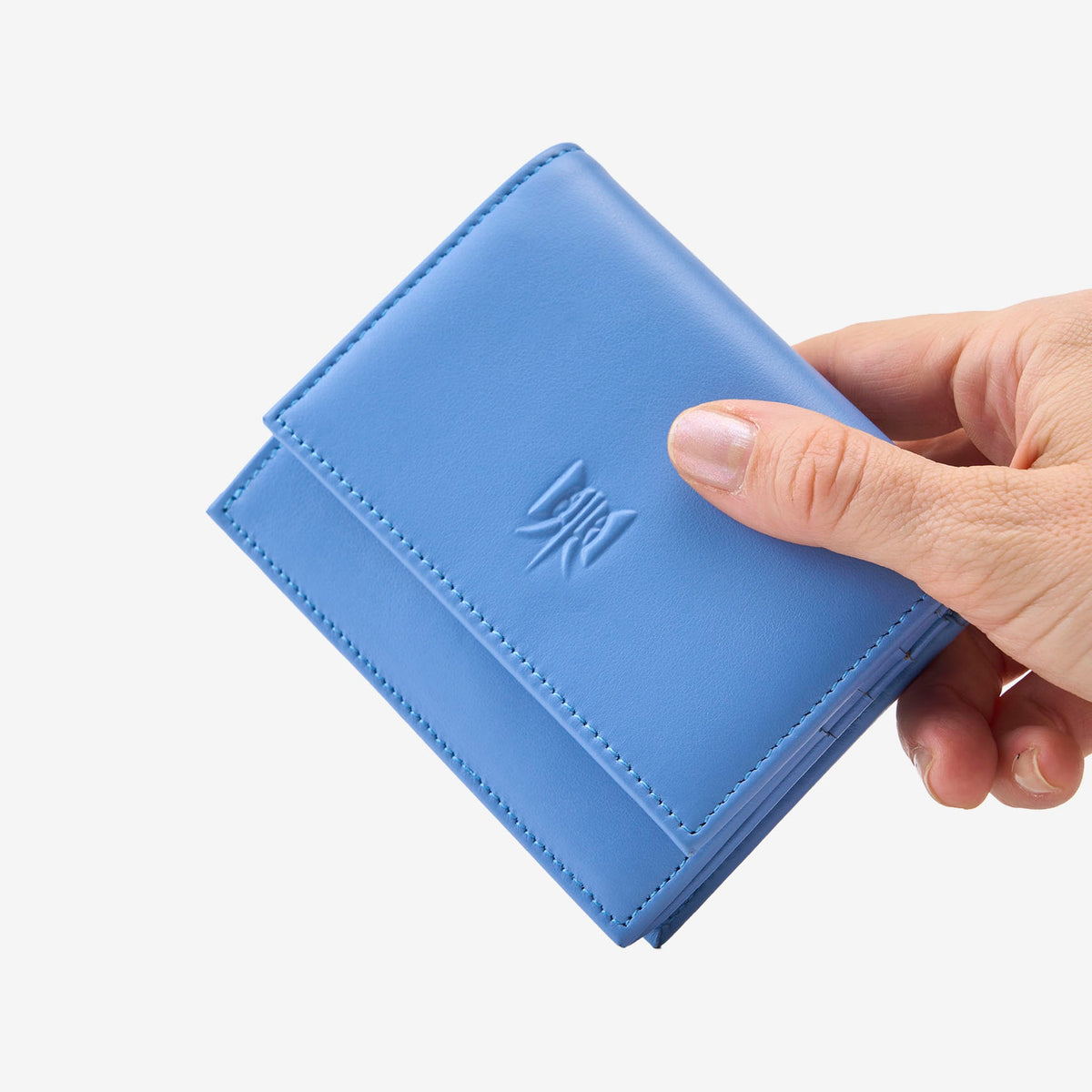Tusk Lille gusseted French leather wallet in French blue, held in hand to show its compact size, view one - FRENCH BLUE