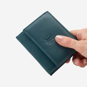 Tusk Lille gusseted French leather wallet in hunter green, held in hand to show its compact size, view one - HUNTER