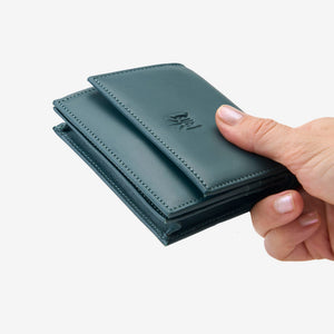Tusk Lille gusseted French leather wallet in hunter green, held in hand to show its compact size, view two - HUNTER