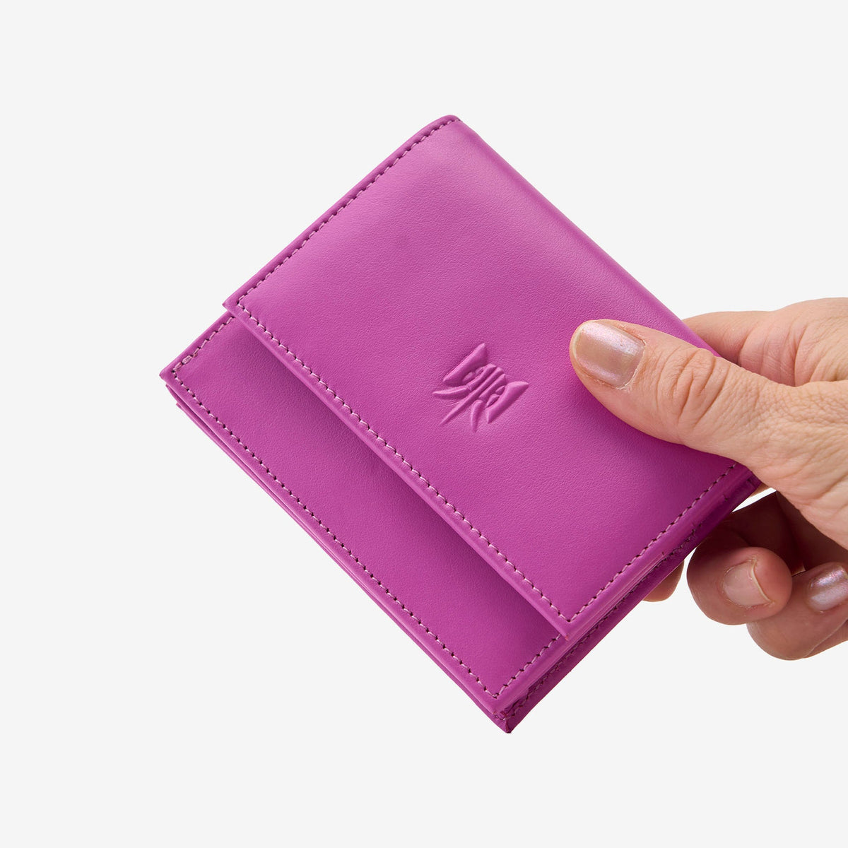 Tusk Lille gusseted French leather wallet in magenta, held in hand to show its compact size, view one - MAGENTA