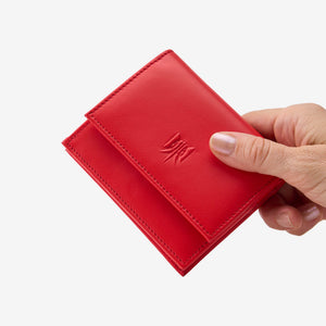 Tusk Lille gusseted French leather wallet in red, held in hand to show its compact size, view one - RED