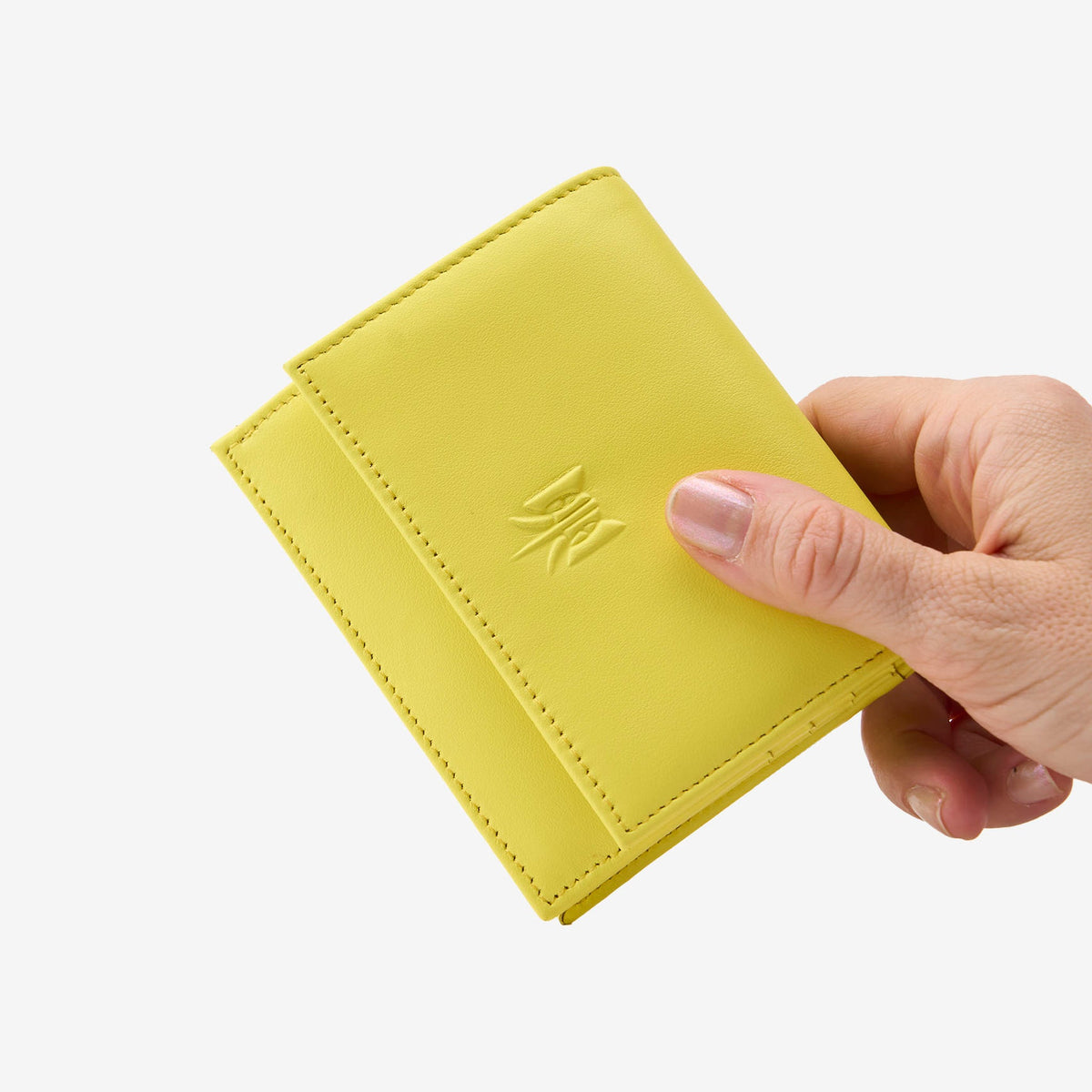 Tusk Lille gusseted French leather wallet in yellow Sun, held in hand to show its compact size, view one - SUN