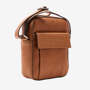 A brown pebbled leather crossbody bag with a front flap pocket and silver-tone hardware, shown on a light gray background - TOAST