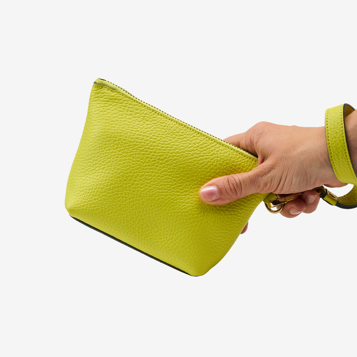 Hand holding an yellow cosmetic beauty pouch against a white background - LIME