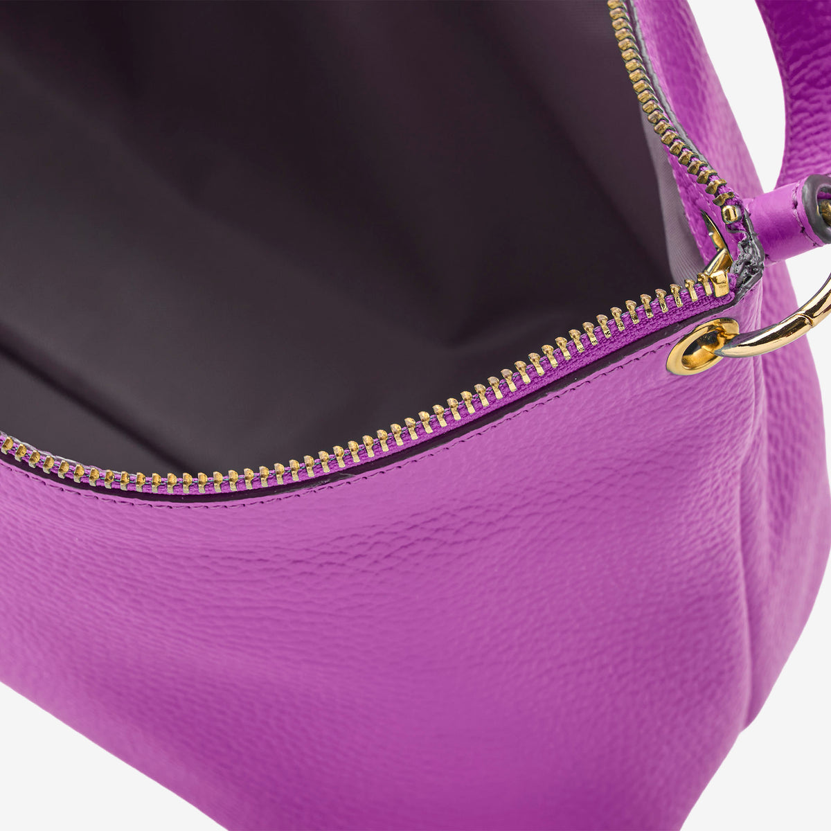 Close-up of a purple handbag with a gold zipper on a white background - MAGENTA