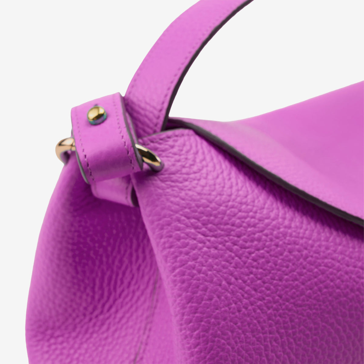 Close-up of a purple handbag with a textured surface and gold accents on a white background - MAGENTA