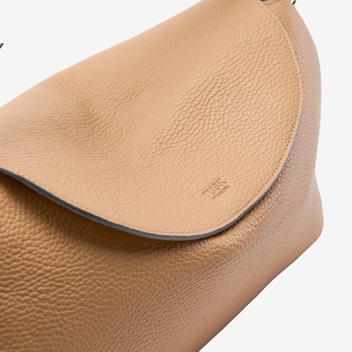 Close-up of a beige Italian leather bag with a visible brand logo on a white background - SAND
