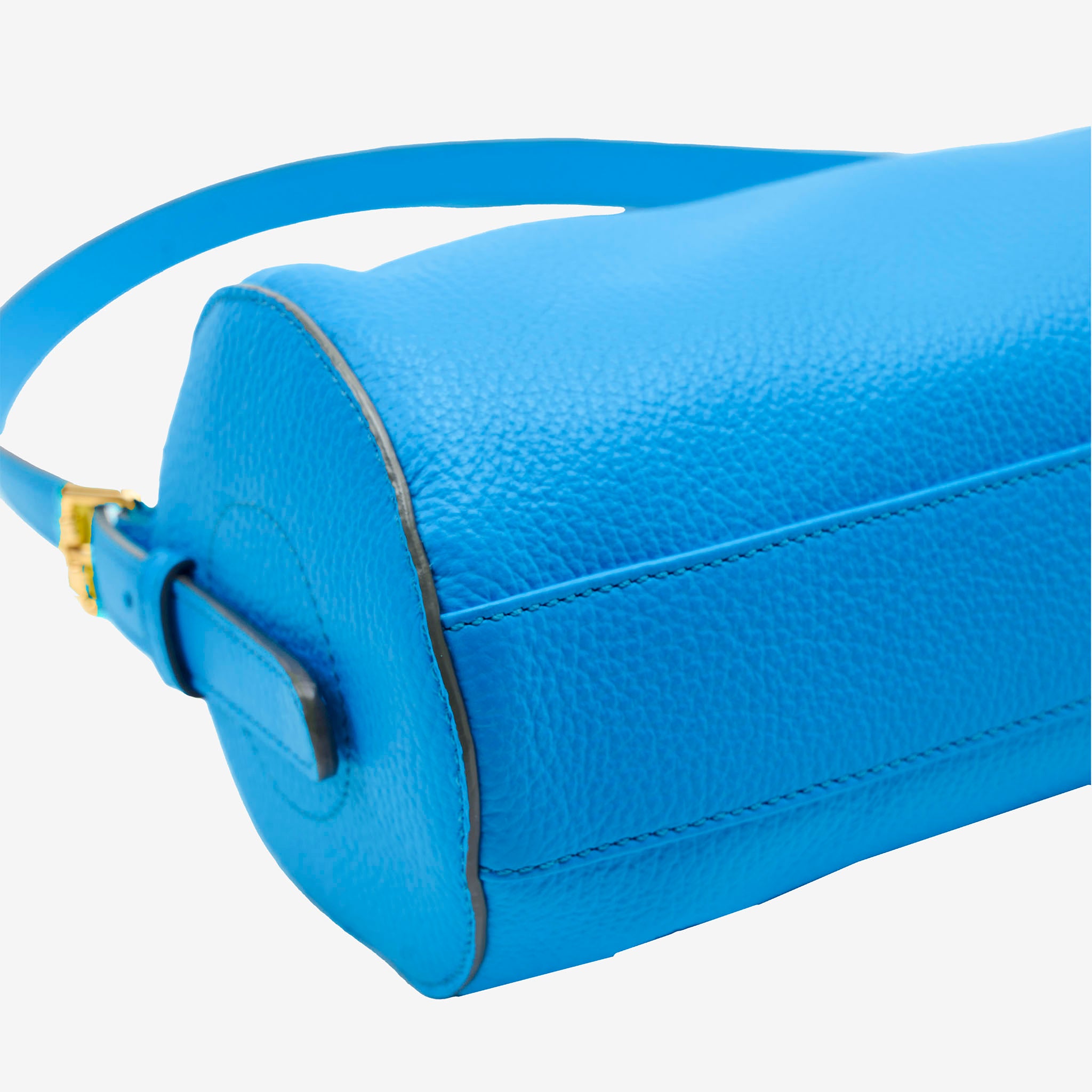 Close-up of a blue leather handbag with a strap on a white background