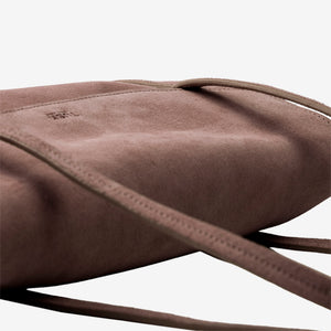 Close-up of a brown suede shoulder bag with a matching leather strap and a debossed logo on the upper left, set against a clean white background - BROWN