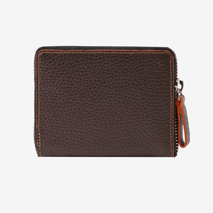Back view of the Tusk Amsterdam men's zip-around wallet in chocolate brown pebble leather, showcasing bright orange contrast perimeter stitching and a brown leather zipper pull tab on a white background - CHOCOLATE