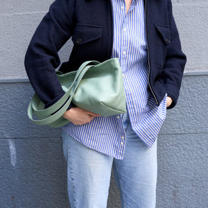 Model carrying the sage green Anaya leather tote under her arm - SAGE